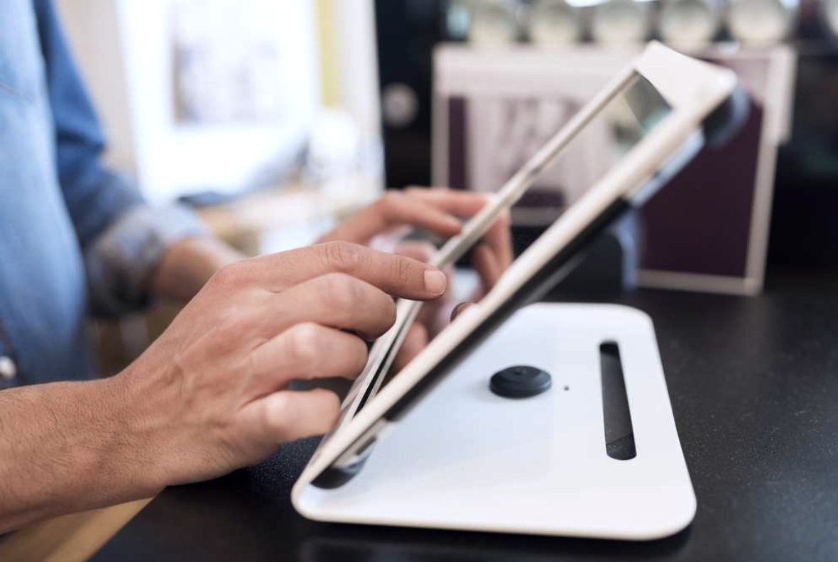 Staff member using a tablet POS at the counter